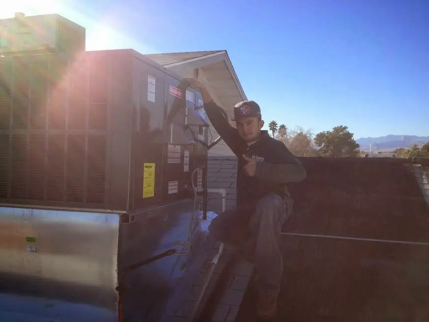 HVAC technician performing Air Duct Cleaning on a rooftop unit in Statesboro